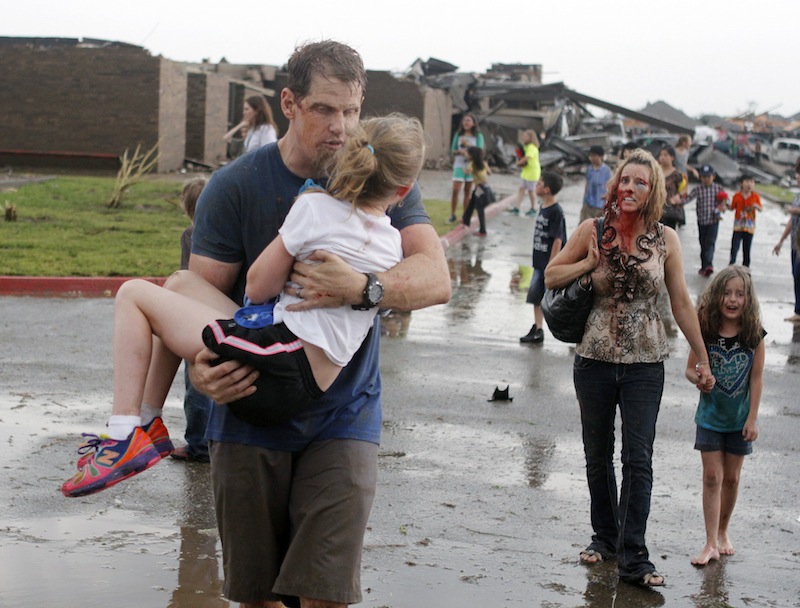 Teachers carry children away from Briarwood Elementary school after a tornado destroyed the school in south Oklahoma City, Monday, May 20, 2013. A monstrous tornado roared through the Oklahoma City suburbs, flattening entire neighborhoods with winds up to 200 mph, setting buildings on fire and landing a direct blow on an elementary school. (AP Photo/The Oklahoman, Paul Hellstern)