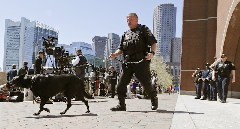 A Department of Homeland Security police officer patrols with his dog outside the Moakley Federal Courthouse in Boston, Mass., Wednesday, May 1, 2013. Three suspects were taken into custody in the Boston Marathon bombing case including two college friends of Dzhokhar Tsarneav, according to officials. (AP Photo/Charles Krupa)