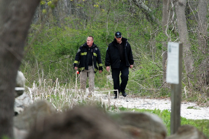 Massachusetts State Police walk out of the woods of The Smith Neck Farm in Dartmouth, Mass. on Friday, May 3, 2013 as federal, state and local authorities on Friday searched the woods near the UMass-Dartmouth campus as part of the marathon investigation. (AP Photo/The Standard-Times, John Sladewski)