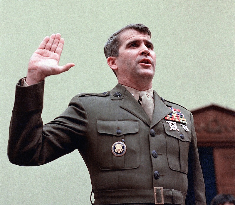 In this Dec. 18, 1986 file photo, Oliver North is sworn in on Capitol Hill in Washington prior to testifying before the House Foreign Affairs Committee. Lois Lerner of the IRS joins a diverse roll call of people who have invoked their Fifth Amendment right not to answer lawmakers’ questions over the years. North cited his Fifth Amendment rights and refused to answer committee question availing the Iran arms sale. (AP Photo/J. Scott Applewhite, File) Arms Raised arms sales Iran Iran-Contra affair military Nicaragua Oath scandals