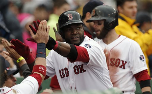 Boston's David Ortiz, center, and Dustin Pedroia, right, are greeted at the dugout after they both scored on a single by Daniel Nava during the eighth inning of their 7-4 win over the Cleveland Indians on Saturday at Fenway Park in Boston.