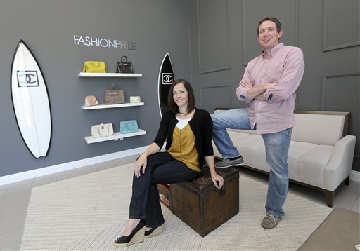 Sarah Davis and Ben Hemmnger, co-owners of Fashionphile.com, pose in the lobby of their Carlsbad, Calif. office on Thursday. The company sells rare, vintage and discontinued previous owned bags, and is facing the complicated task of dealing with new state regulations on Internet sale taxes.