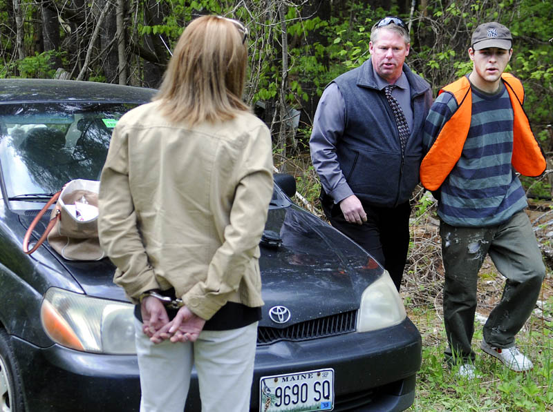 Kennebec County Sheriff's Office Detective Dave Bucknam, center, escorts Brock Hamilton, right, from behind a barn in Manchester Tuesday, which deputies claim he was burglarizing when they arrived. Deputies also detained Tonia Sirois, 30, of Augusta, left, who summonsed on theft and criminal trespass charges.