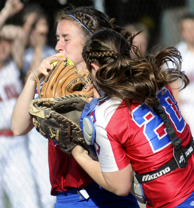 LOOK OUT: Oak Hill High School’s Brooke LeBel, right, and Sadie Goulet collide while chasing a foul ball at home plate during the Raiders’ 3-1 win over Hall-Dale on Wednesday in Farmingdale.