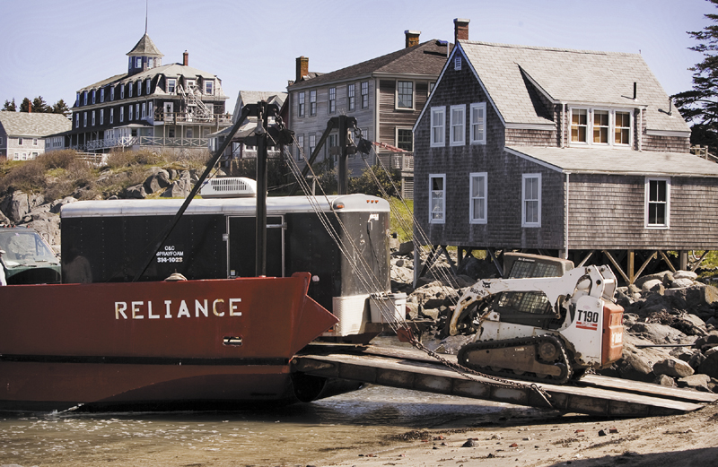 As part of an Island Institute program to make Maine island homes more energy efficient, contractors are transported via barge to Monhegan to eliminate air leaks on many island homes with weather sealing and spray insulation.