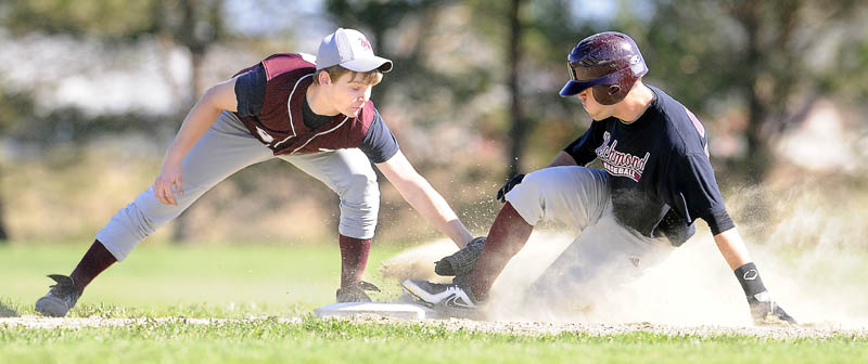 Richmond High School’s Eddie Stewart slides safely under the tag by Buckfield High School’s Owen Bennett at second base Tuesday in Richmond. The Bobcats won 5-4. For local roundup, see C3.