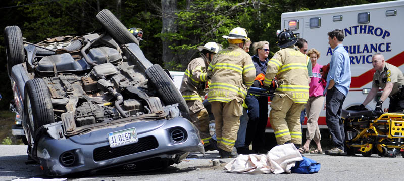 Rescue workers carry a 17-year-old Leeds driver to an ambulance Sunday, after the sport utility vehicle she was driving rolled over in Wayne.