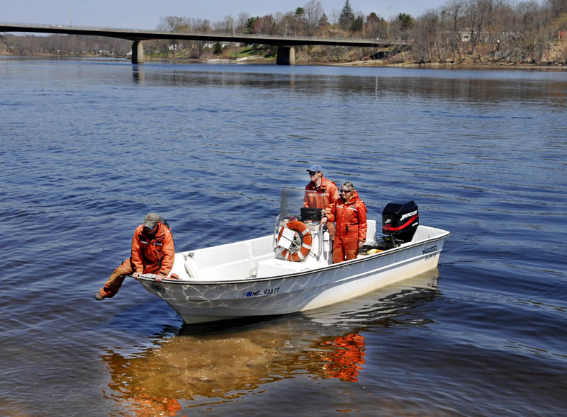 Maine Department of Marine Resources technician Jason Beaudry leaps out of a boat in Gardiner recently after searching the Kennebec River with biologists Jason Bartlett, center, and Gail Whipplehauser with a side scan sonar between Gardiner and Augusta. According to Whipplehauser, the scientists are collecting data on the migration of sturgeon, shad and herring that spawn in the river through mid-July.