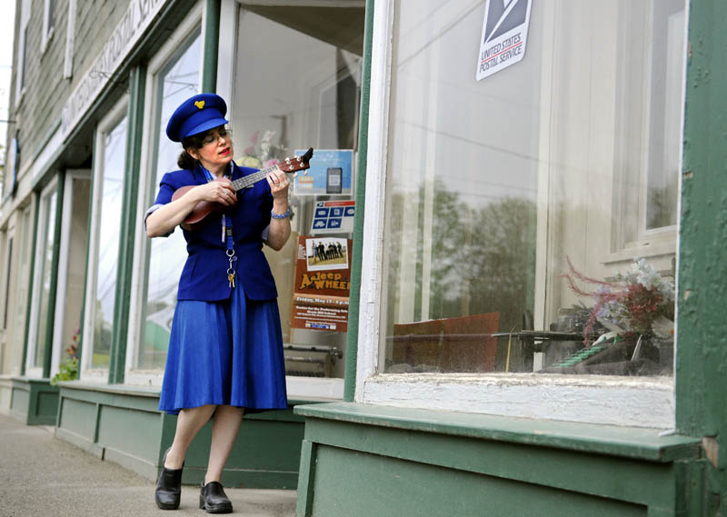 Justine Fontes strums a ukulele on Thursday outside the Readfield Post Office, where she is serving as the relief postmaster. The stringed music serenades customers collecting mail and people walking down the main street of Readfield, according to Fontes. "04355 is the best little zip in Maine," Fontes said.