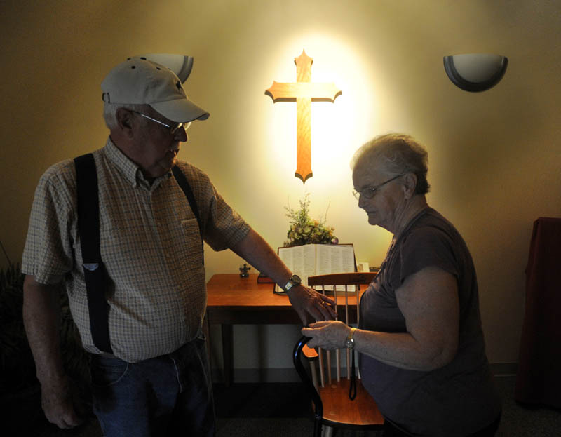 Gerald "Jake" Ellis, 79, reaches for the hand of his wife Pauline Ellis, 79, after saying the Lord's prayer in the chapel at Lakewood Nursing Home in Waterville Wednesday morning. Pauline is a resident in the nursing home's dementia ward.