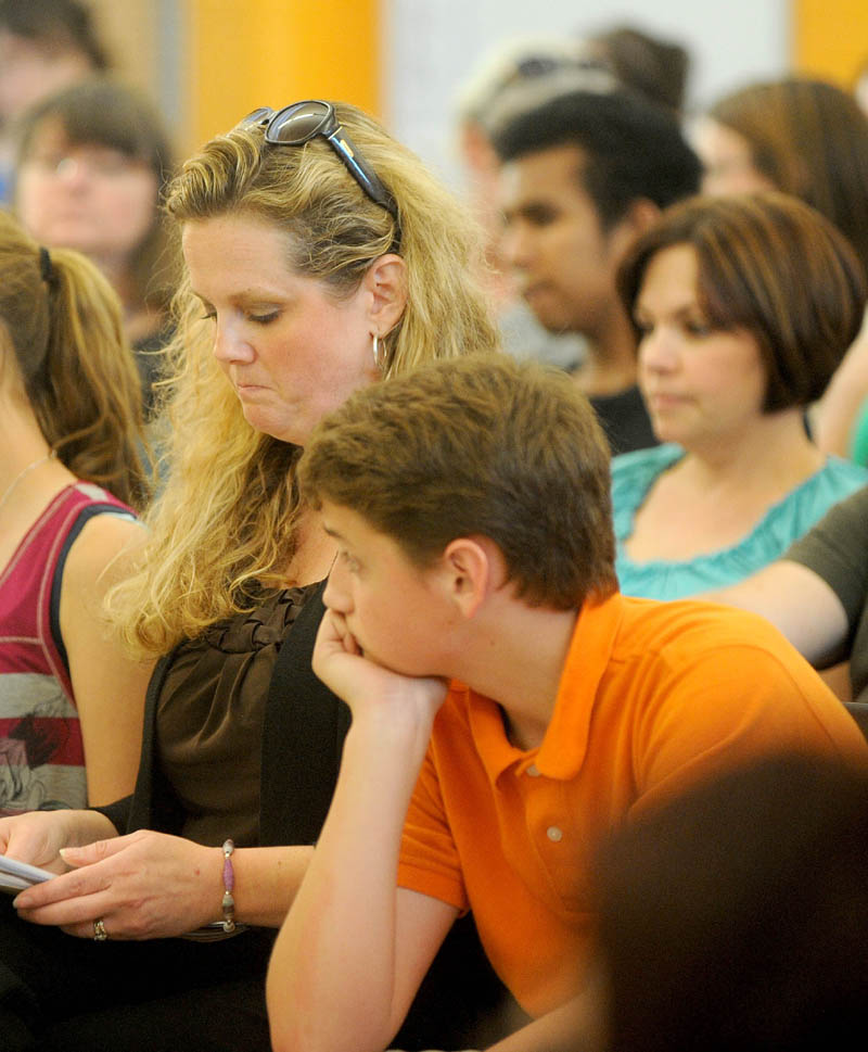 Erika Russell, center with her son Max at Messalonskee Junior High School during a special school board meeting at Messalonskee Junior High School in Oakland on Thursday.