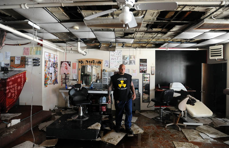 Bill Juliano, 38, owner of Ink-4-Life, located on the first floor of the Main Street building gutted by fire Friday, sifts through his tattoo equipment Saturday morning.
