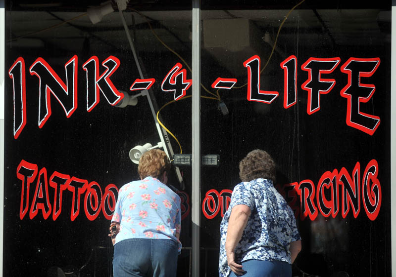People peer into Ink-4-Life, on the first floor of a building on Main Street, Saturday morning.