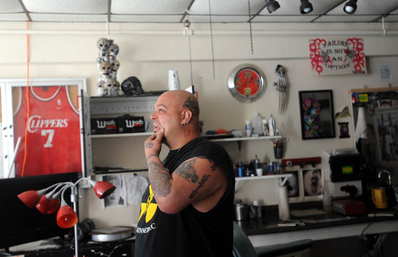 Bill Juliano reacts as he looks around his fire-damaged tattoo studio, Ink-4-Life, Saturday morning.