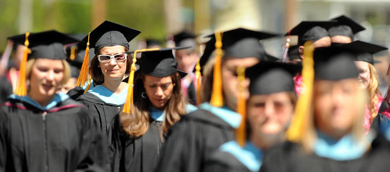 Graduates of the University of Maine at Farmington march down High Street during commencement ceremonies in Farmington on Saturday.