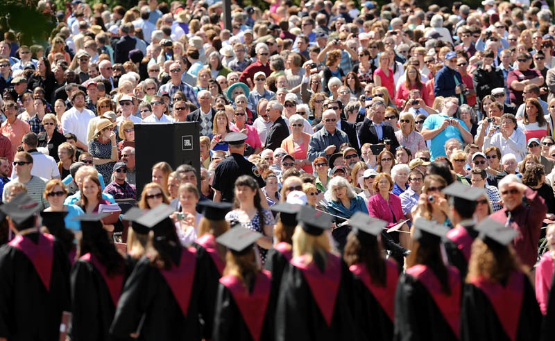 Graduates of the University of Maine at Farmington march past friends and family on High Street during commencement ceremonies in Farmington on Saturday.
