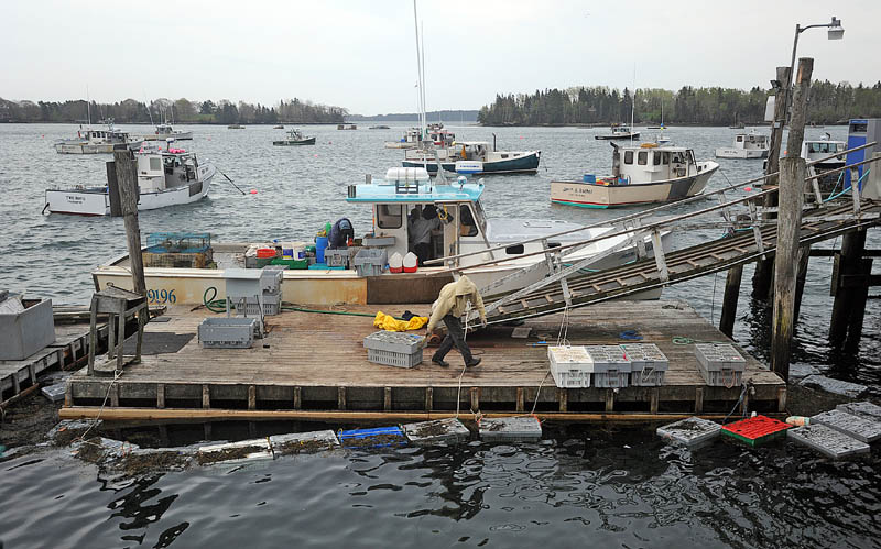 Craig Mott, 36, center, the dock manager at the Friendship Lobster Co-Op, helps unload the day's lobster haul from the Miss Kylie in Friendship Harbor on Wednesday.