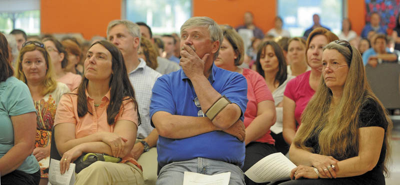 Wayne Cormier, center, listens to a PowerPoint presentation at Messalonskee Middle School during a special school board meeting Thursday night.