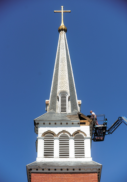Workers from Corpus Christi Parish in Waterville prepare the steeple for removal during the demolition of St. Francis de Sales on Thursday.