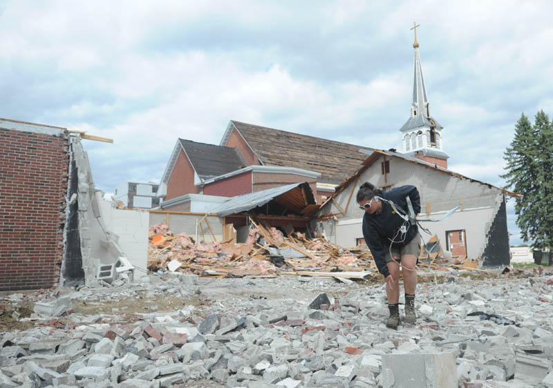 Gina Surrette, of Danley Demolition, Inc., picks metal pieces from crushed concrete during the demolition of St. Francis de Sales Catholic Church, its rectory and its parish hall, on Elm Street in downtown Waterville on Tuesday.