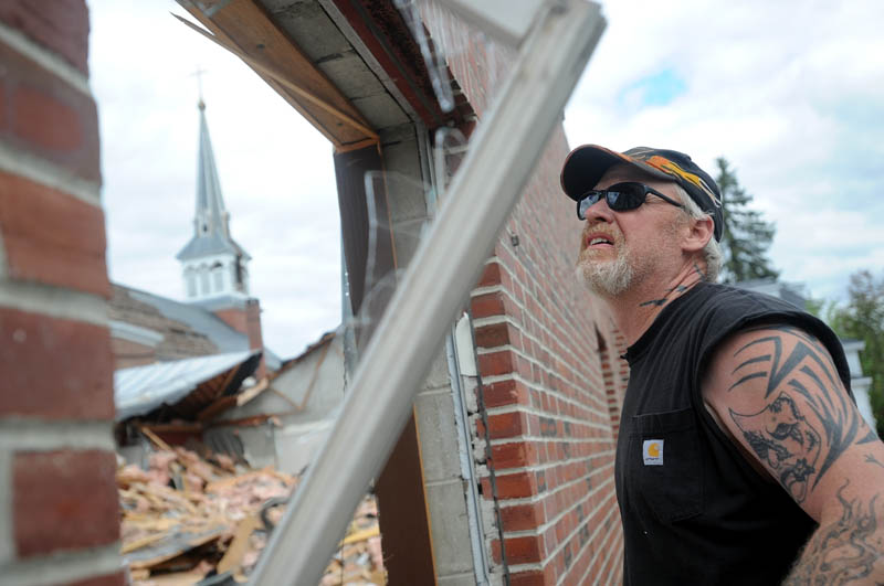 Kip Walker, a heavy machine operator for Danley Demolition, Inc., tears off a wood sill during demolition of St. Francis de Sales Catholic Church, its rectory and its parish hall, on Elm Street in downtown Waterville on Tuesday.