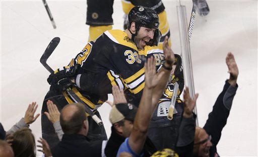 Boston Bruins center Patrice Bergeron, right, is embraced by teammate Zdeno Chara, left, after scoring the game winning goal off Toronto Maple Leafs goalie James Reimer during overtime in Game 7 of their NHL hockey Stanley Cup playoff series in Boston, Monday, May 13, 2013. The Bruins won 5-4. (AP Photo/Charles Krupa)