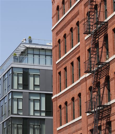 A modern luxury glass apartment building, left, sits across the street from an older red brick apartment, the home of photographer Arne Svenson.