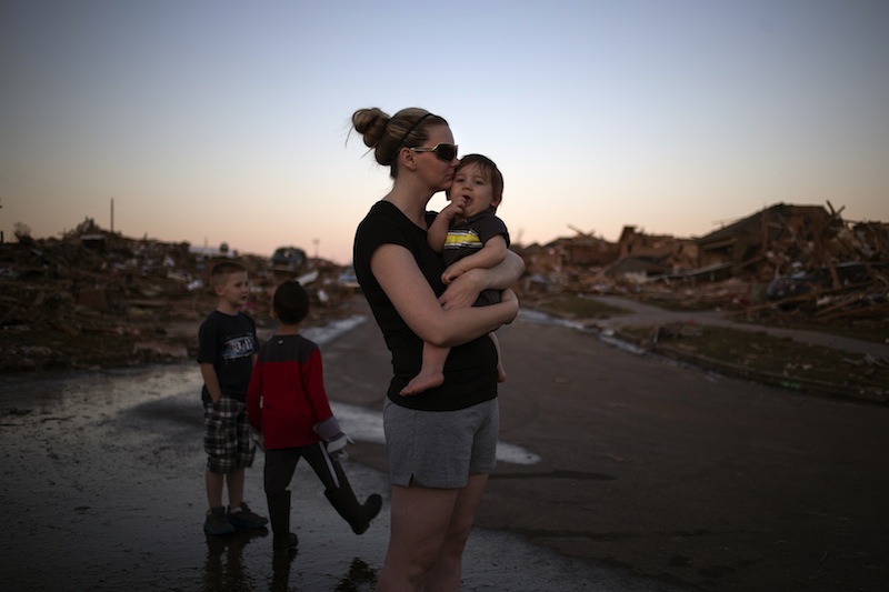 Rae Kittrell holds her son Rylan, who turned one-year-old today, a block away from her house in Moore, Oklahoma, two days after the Oklahoma City suburb was left devastated by a tornado on May 22, 2013. Kittrell's house survived the tornado. Tornado survivors thanked God, sturdy closets and luck in explaining how they lived through the colossal twister that devastated an Oklahoma town and killed 24 people, an astonishingly low toll given the extent of destruction. (REUTERS/Adrees Latif) :rel:d:bm:GF2E95N04TH01