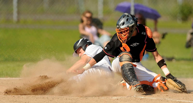 SAFE: Waterville Senior High School’s Racean Wood, left, slides by Winslow High School catcher Bobby Chenard for a run in the fifth inning of the Kennebec Valley Athletic COnference Class B championship game in Winslow on Friday. Waterville defeated Winslow 10-0 in six innings.
