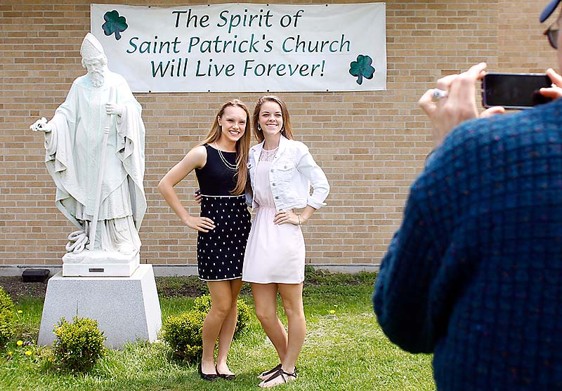 Austin Taylor of Portland photographs his daughter Rachel Taylor, 16, left, and Meghan Connolly, 15, next to the statue of Saint Patrick before the final service at St. Patrick Church. The girls were St. Patrick School classmates before it closed in 2007.