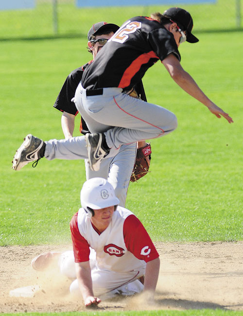 LOOK OUT: Skowhegan shortstop Kameron Wallace leaps out of the way of sliding Cony baserunner Mitchell Caron on Friday in Augusta.