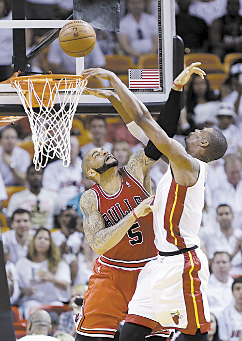 EVEN AS CAN BE: Miami Heat center Chris Bosh, right, is fouled by Chicago Bulls forward Carlos Boozer (5) as he goes up for a shot during Game 2 of their Eastern Conference semifinal Wednesday in Miami.