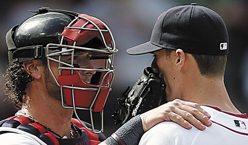HONORING MOTHERS: With his finger nails painted pink for Mother’s Day, Boston Red Sox catcher Jarrod Saltalamacchia, left, talks with relief pitcher Clayton Mortensen during the sixth inning against the Toronto Blue Jays on Sunday at Fenway Park in Boston.
