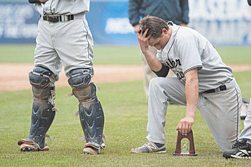 TOUGH DAY: University of Southern Maine’s Troy Thibodeau leans down on the trophy during the postgame ceremony after the championship game against Linfield on Tuesday at Time Warner Cable Field in Appleton, Wis. The Huskies lost 4-1.
