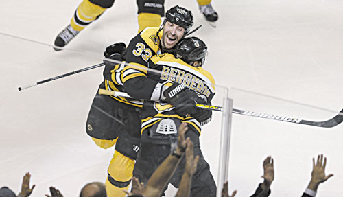 CELEBRATE: Boston center Patrice Bergeron (37) is embraced by teammate Zdeno Chara after scoring the game-winning goal off Toronto goalie James Reimer during overtime in Game 7 of their Stanley Cup series Monday in Boston,. The Bruins won 5-4.