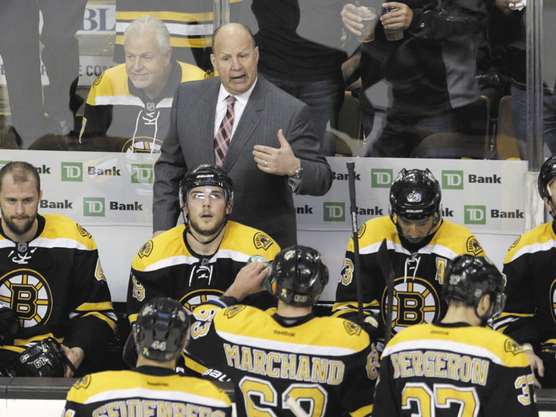 Boston Bruins head coach Claude Julien, standing center, talks with his players during a timeout against the New York Rangers during the third period in Game 5 of the Eastern Conference semifinals in the NHL hockey Stanley Cup playoffs in Boston, Saturday, May 25, 2013. (AP Photo/Charles Krupa)
