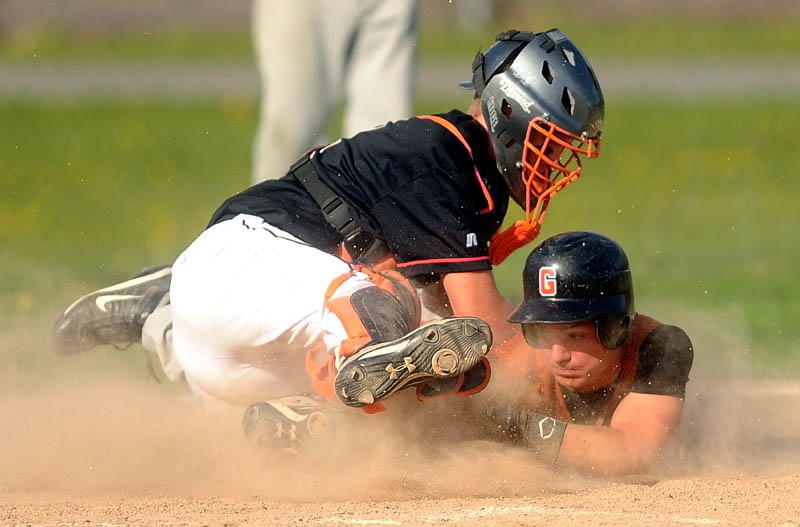 Winslow High School catcher Bobby Chenard, left, tags out Gardiner High School’s Frank Chepke on a steal attempt in the fifth inning Wednesday at Winslow High School. The Black Raiders defeated the Tigers 1-0.