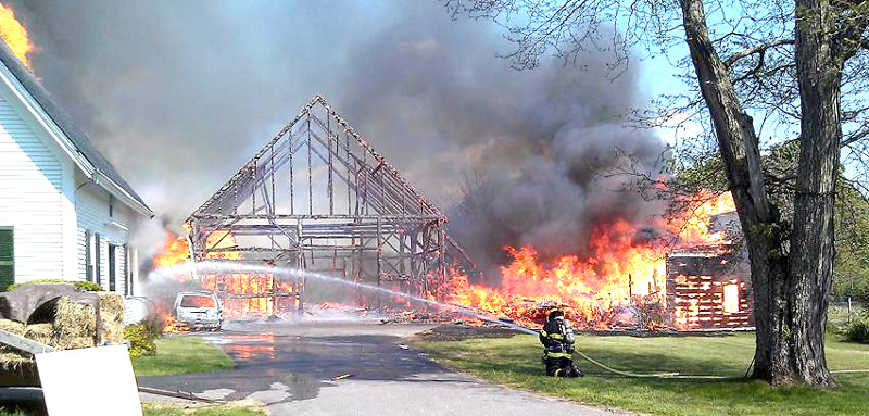 Firefighters battle a fire on the Hallowell-Litchfield Road in Litchfield on Friday.