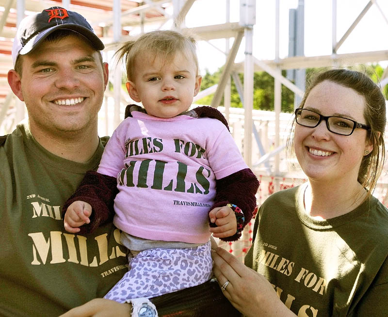 Staff Sgt. Travis Mills, left, holds his daughter, Chloe, next to his wife, Kelsey Buck Mills, after the second annual Miles For Mills 5k on Monday at Cony High School in Augusta.