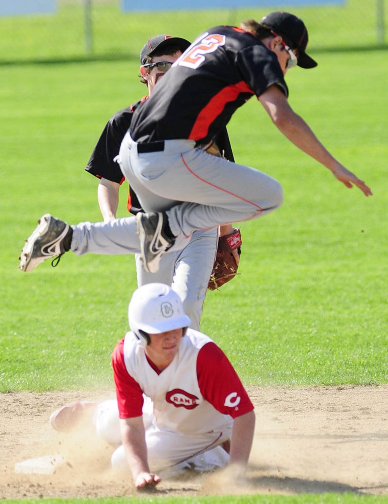 Staff photo by Joe Phelan Skowhegan shortstop Kameron Nelson leaps out of way of sliding Cony baserunner Mitchell Caron during a game on Friday May, 10 2013 in Augusta.