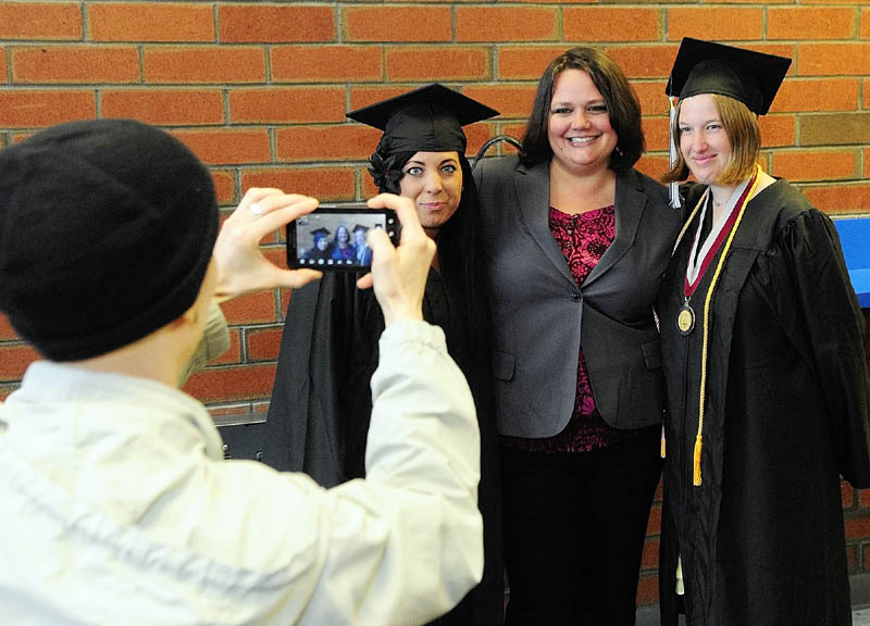 Emily Naples, left, snaps a camera phone photo of Rillyria Sherifi, Tessa Pyles and Tessa Hayes before the University of Maine at Augusta graduation on Saturday at the Augusta Civic Center.