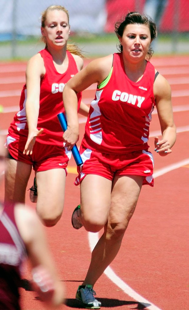 HAND OFF: Cony’s Sarah Smith, left, drops back after handing the baton to teammate Lindsey Folsom in the 4x100-meter relay during the Kennebec Valley Athletic Conference Track and Field Championships on Monday in Bath.