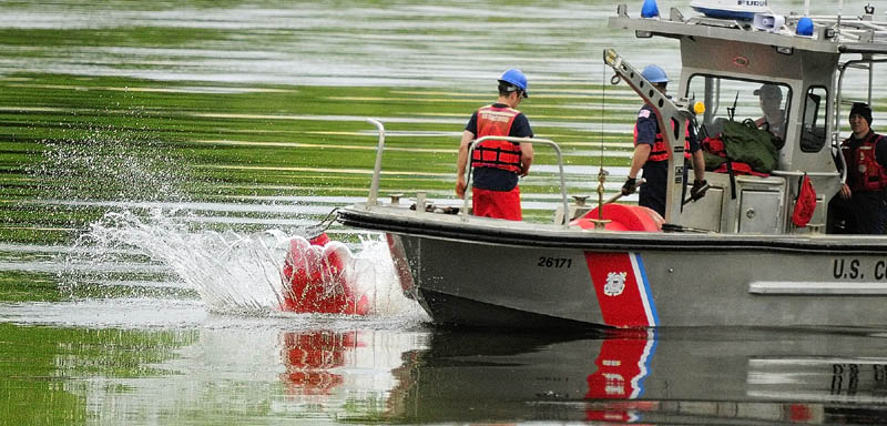 Coast Guardsmen drop a bouy into the Kennebec River on Wednesday between Chelsea and Hallowell.