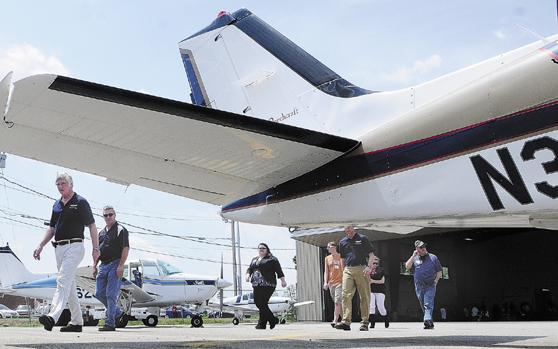 David Smith, Maine Instrument Flight's chief pilot, leads a line of riders who won a raffle out to a Beechcraft Bonanza for a ride during the University of Maine at Augusta bachelor of science in aviation's open-hangar day event on Friday at the Augusta State Airport.