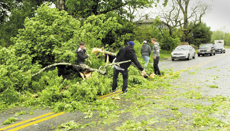 Several men got out of their cars clear a fallen tree from the westbound lane of Route 17 on Saturday in Readfield. The group, who said they were Kents Hill School alumni enroute to graduation there, removed what limbs and branches they could by hand. That cleared the view of the road so drivers could see if oncoming traffic. Shortly after that, two other men with chainsaws removed the trunk.