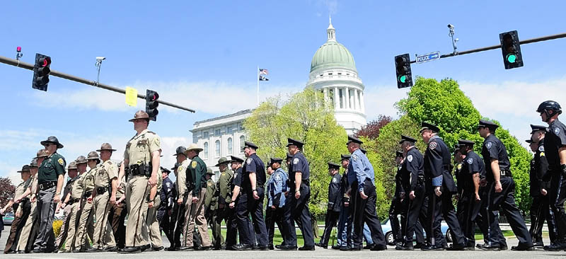 Law enforcement officers march around the corner from Union Street onto to State Street on their way to the Law Enforcement Memorial during a ceremony on Thursday near the State House in Augusta. Attorney General Janet Mills was the keynote speaker for the 23rd annual event, which focus' on the granite plaques with the names of the officers who have killed in the line of duty. There were no new names to be added this year.