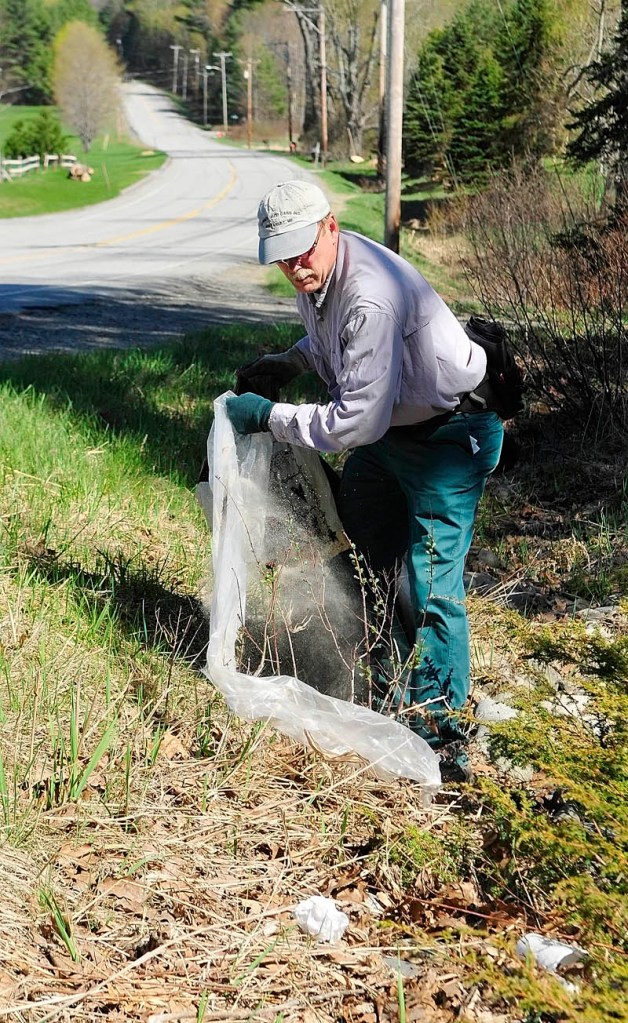 Gary Hinkley picks up trash along Route 17 on Saturday in Manchester. He was part of the Manchester Conservation Commission's annual roadside cleanup event. More than 40 people helped to pull trash, tires, and recyclables off the roadsides. Boy Scouts Troop 622, Cub Scout Pack 622 and the Hope Baptist Church were involved in the event.