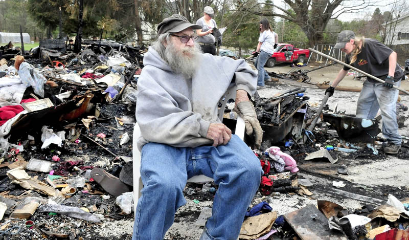 Clyde Berry on Thursday speaks about the offers of help he has received amid the rubble of his home in Benton that was destroyed by fire Monday. Looking for salvageable items in background are Barbara Berry, left, Jayme Sabins and Derrick Berry.