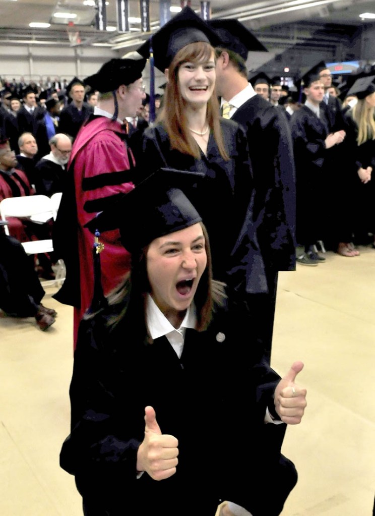 Colby College student Danielle Dellarco gives thumbs-up to family members as she and other graduates received their diplomas during commencement in Waterville on Sunday.