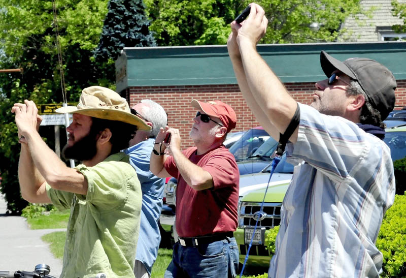 A crowd of onlookers including Dave Begin, center, watch and photograph the cross and steeple removal on top of St. Francis de Sales Catholic Church in Waterville on Tuesday, May 28, 2013.